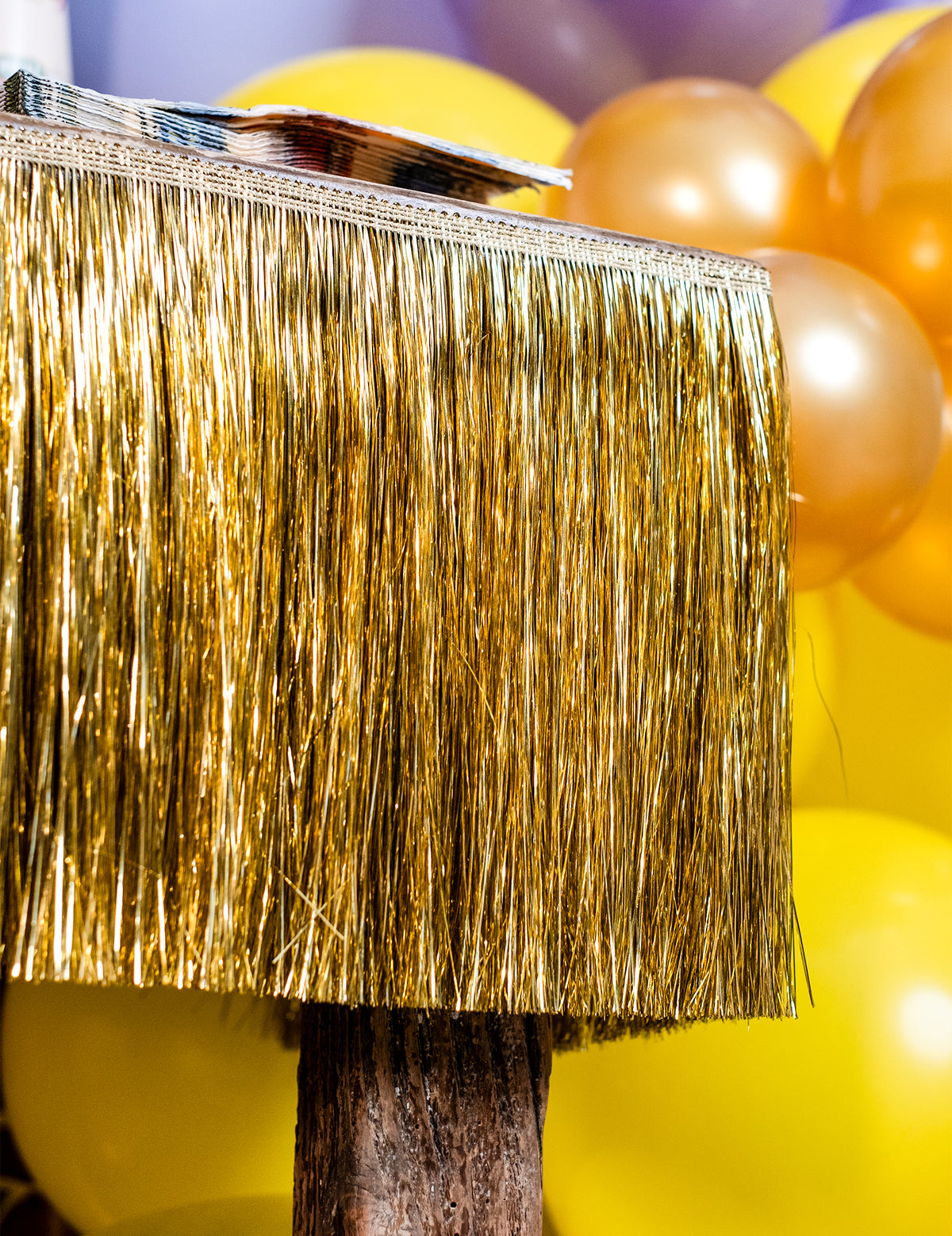 Gros plan sur la texture scintillante de la guirlande de fils à franges dorés pour fête