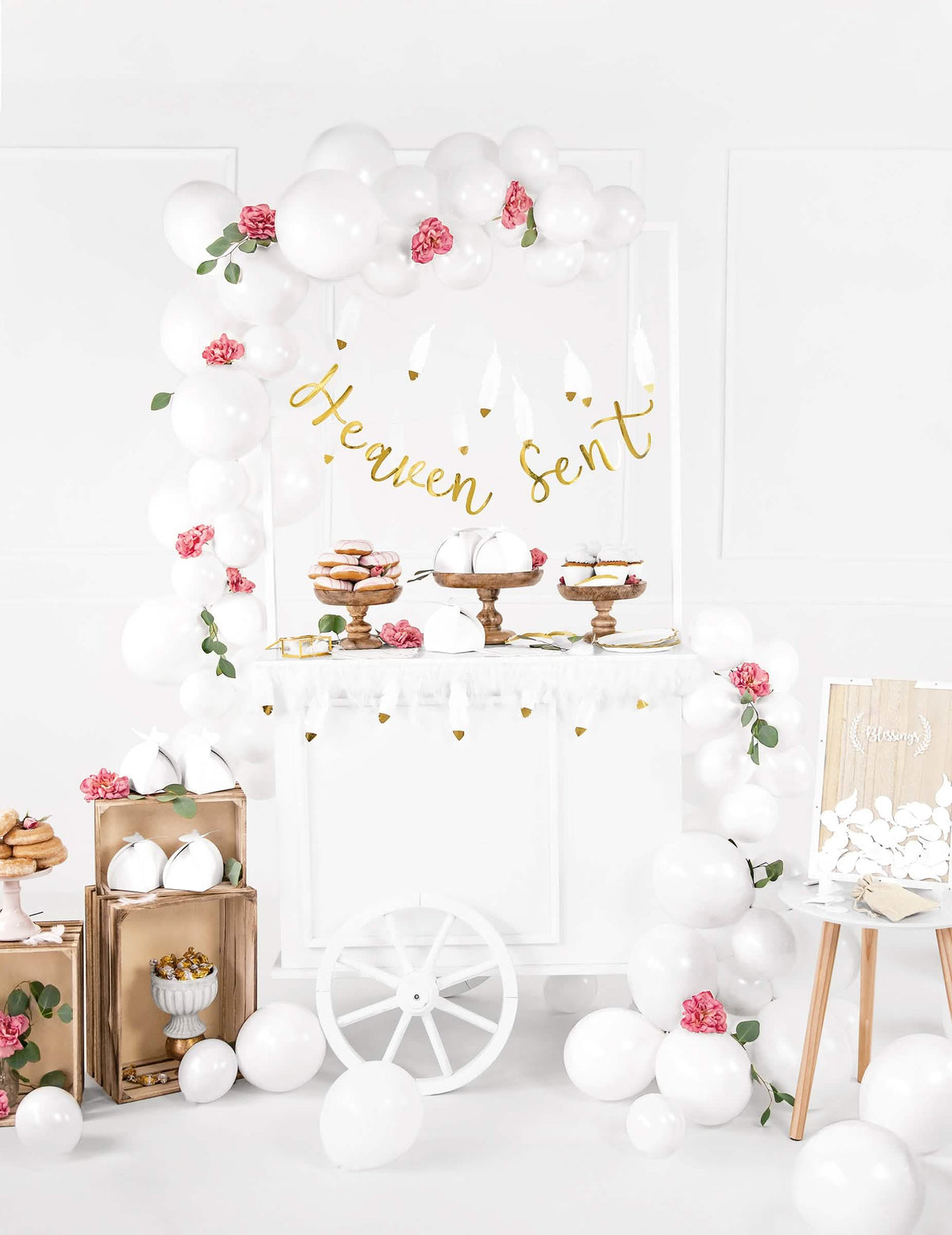 Encenação numa mesa de doces com a grinalda de penas casamento para festa