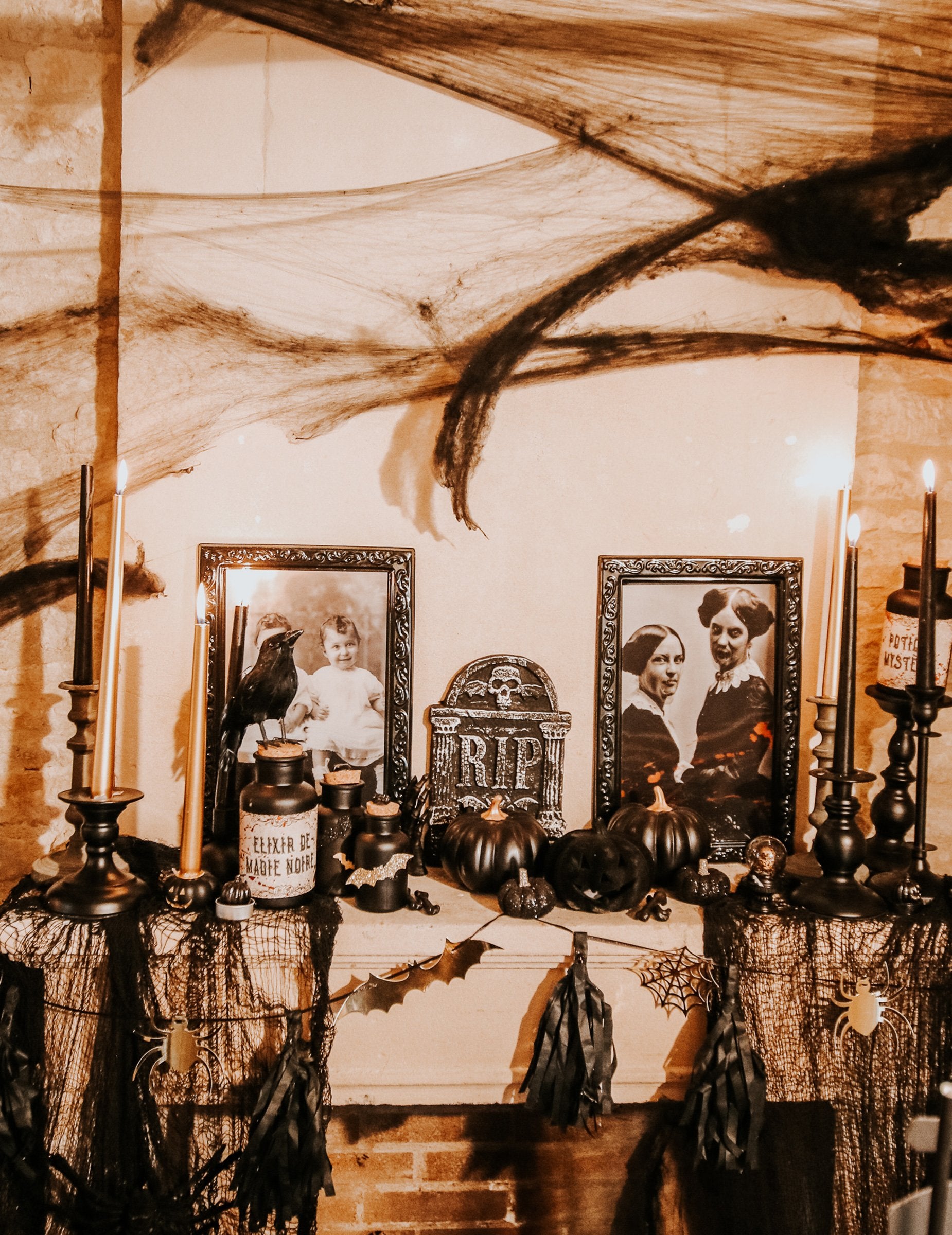 Mise en situation sur une cheminée de la guirlande Halloween noire et or avec tassels