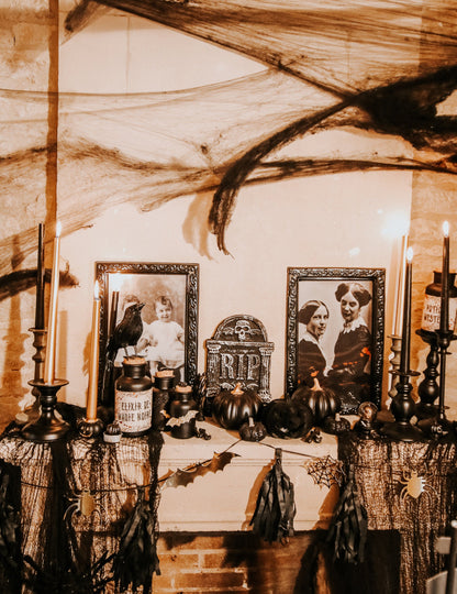 Mise en situation sur une cheminée de la guirlande Halloween noire et or avec tassels