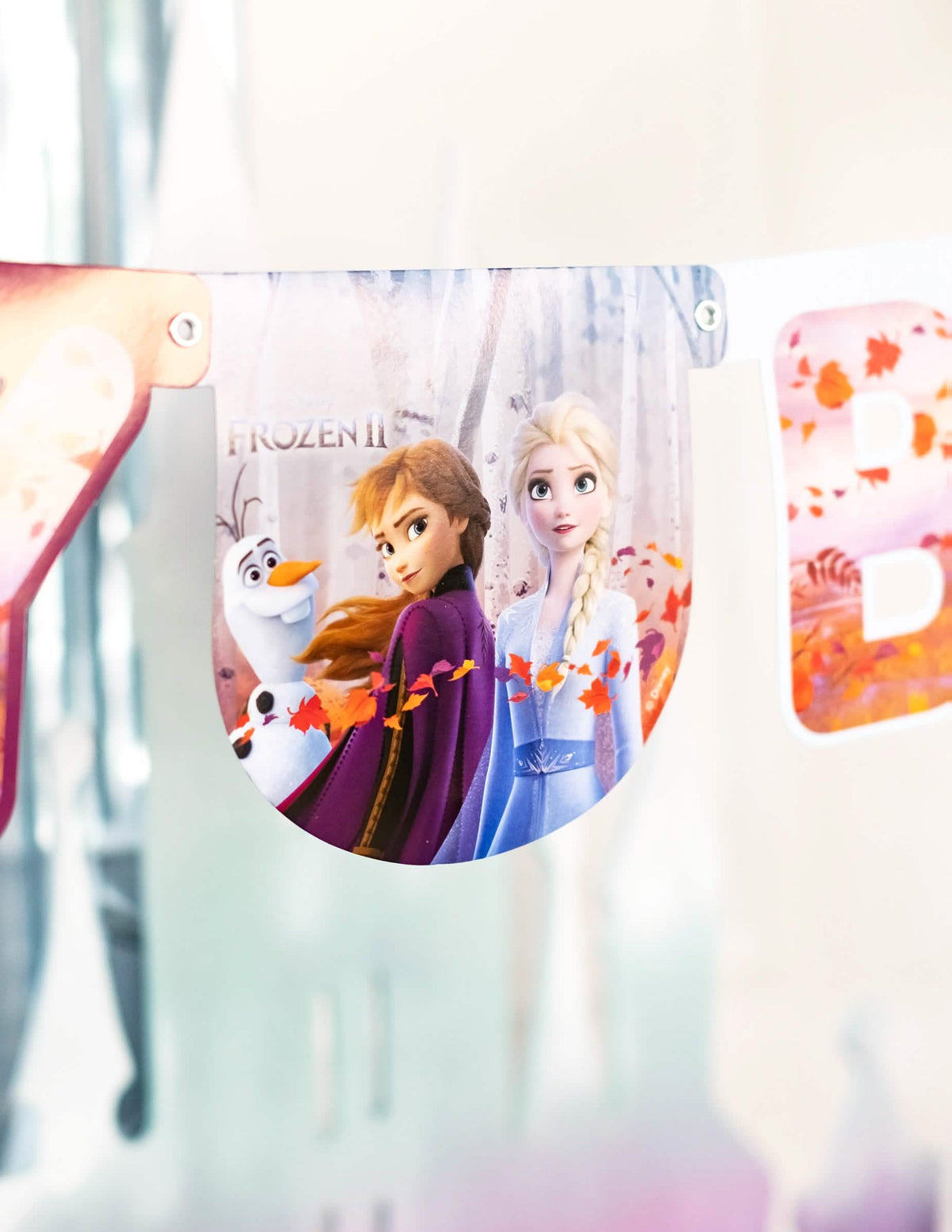 Detalhe do pendão com Anna, Elsa e Olaf da grinalda happy birthday Frozen 2
