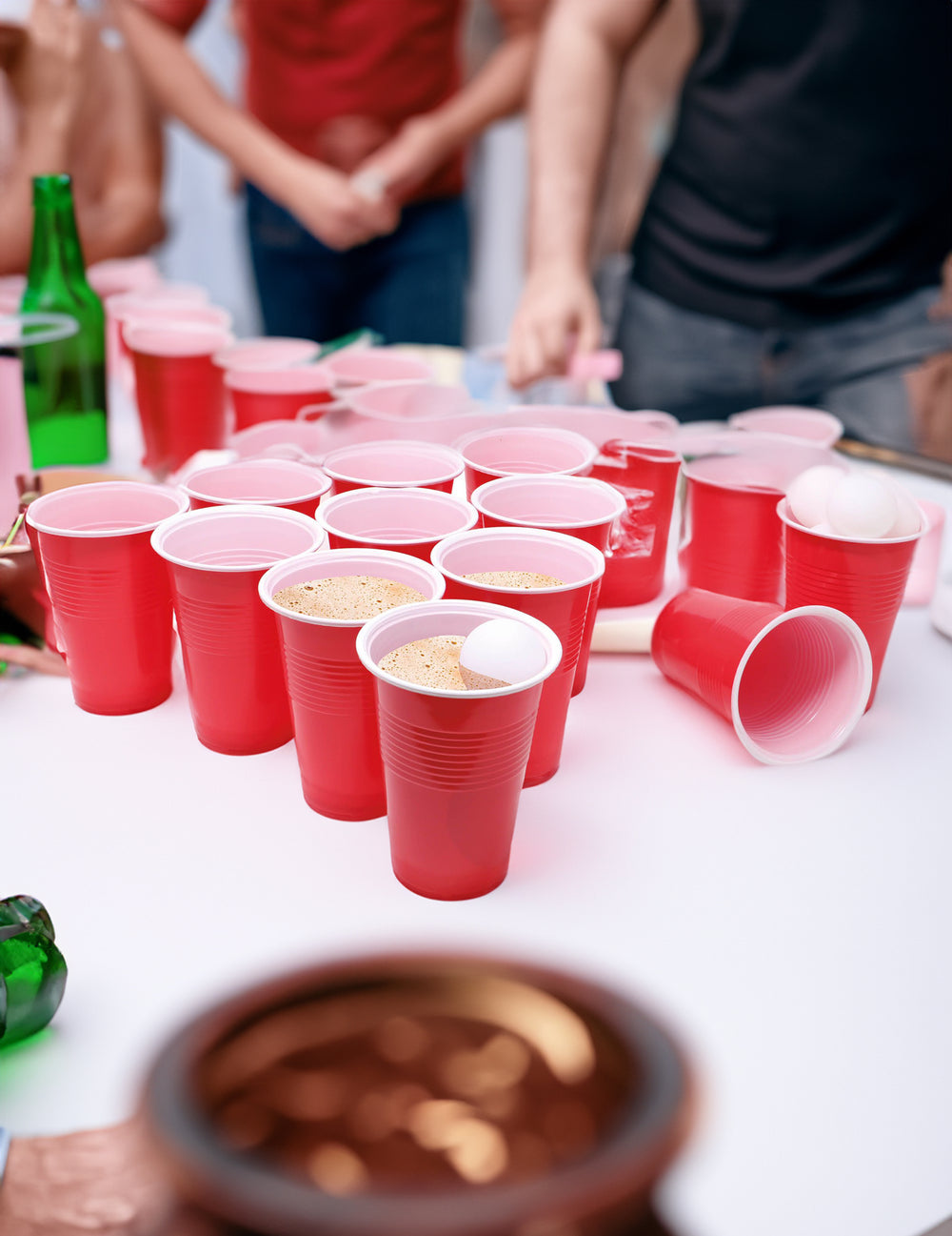 Balle blanche dans un gobelet rempli de bière du jeu de beer pong avec gobelets et balles