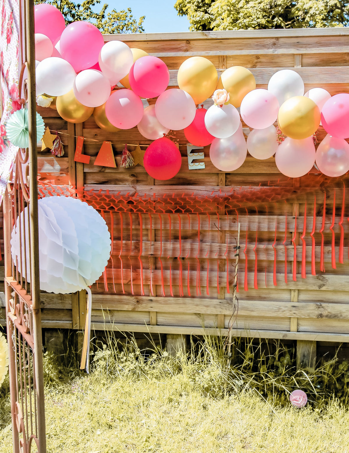Mise en situation du kit arche de 50 ballons décoration florale rose et or avec pivoines et eucalyptus