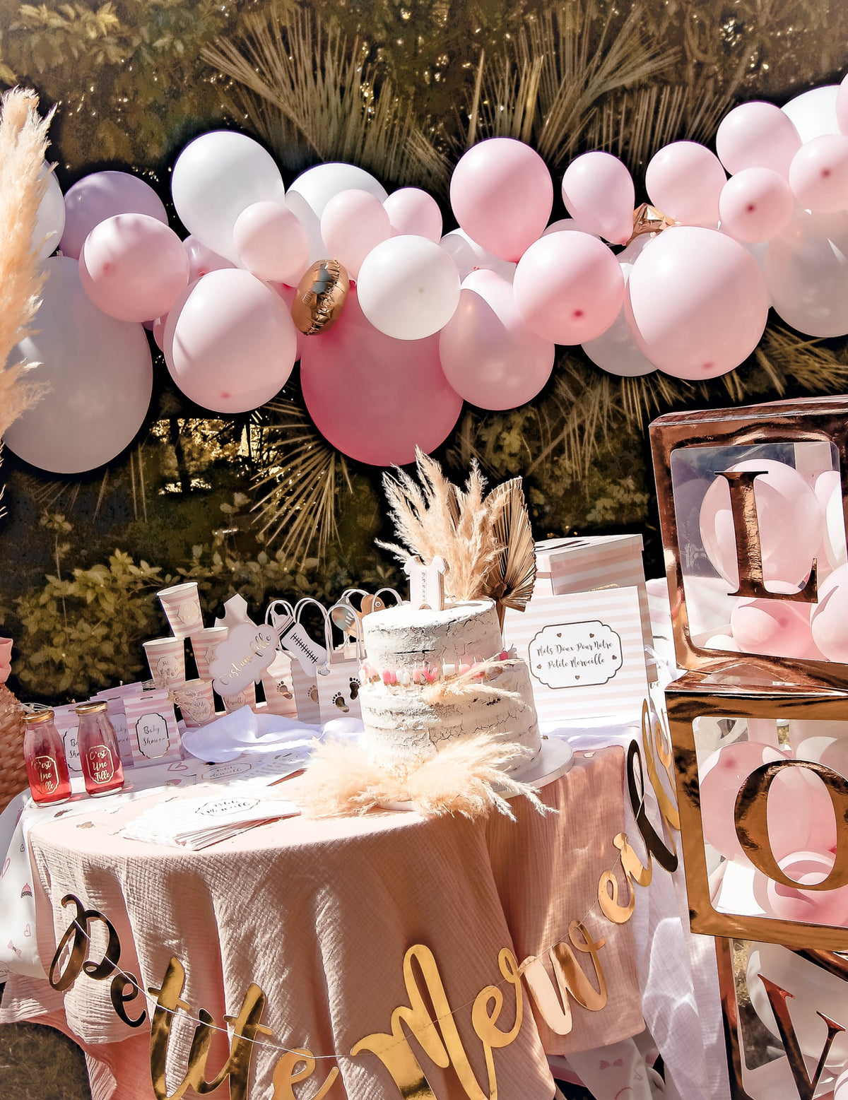 Mise en scène décorative du kit arche de 57 ballons pour fête rose et blanche et or