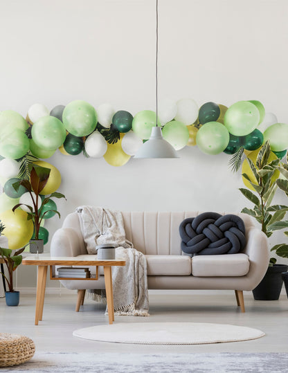 Mise en scène dans un salon du kit arche de 70 ballons tropicale et feuilles jungle