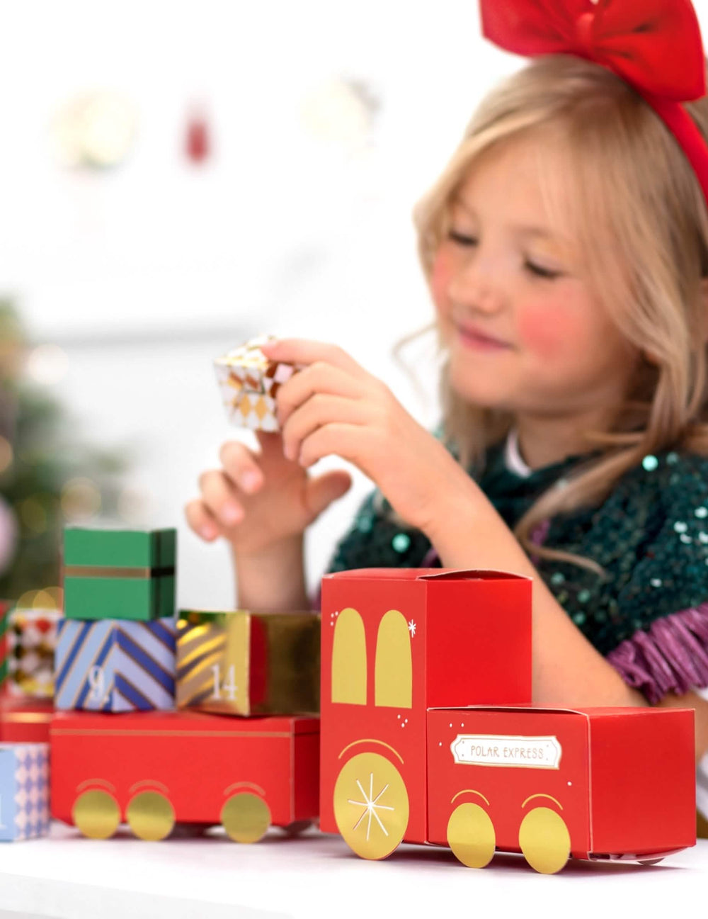 criança a manusear uma caixa do kit calendário do advento DIY comboio de natal