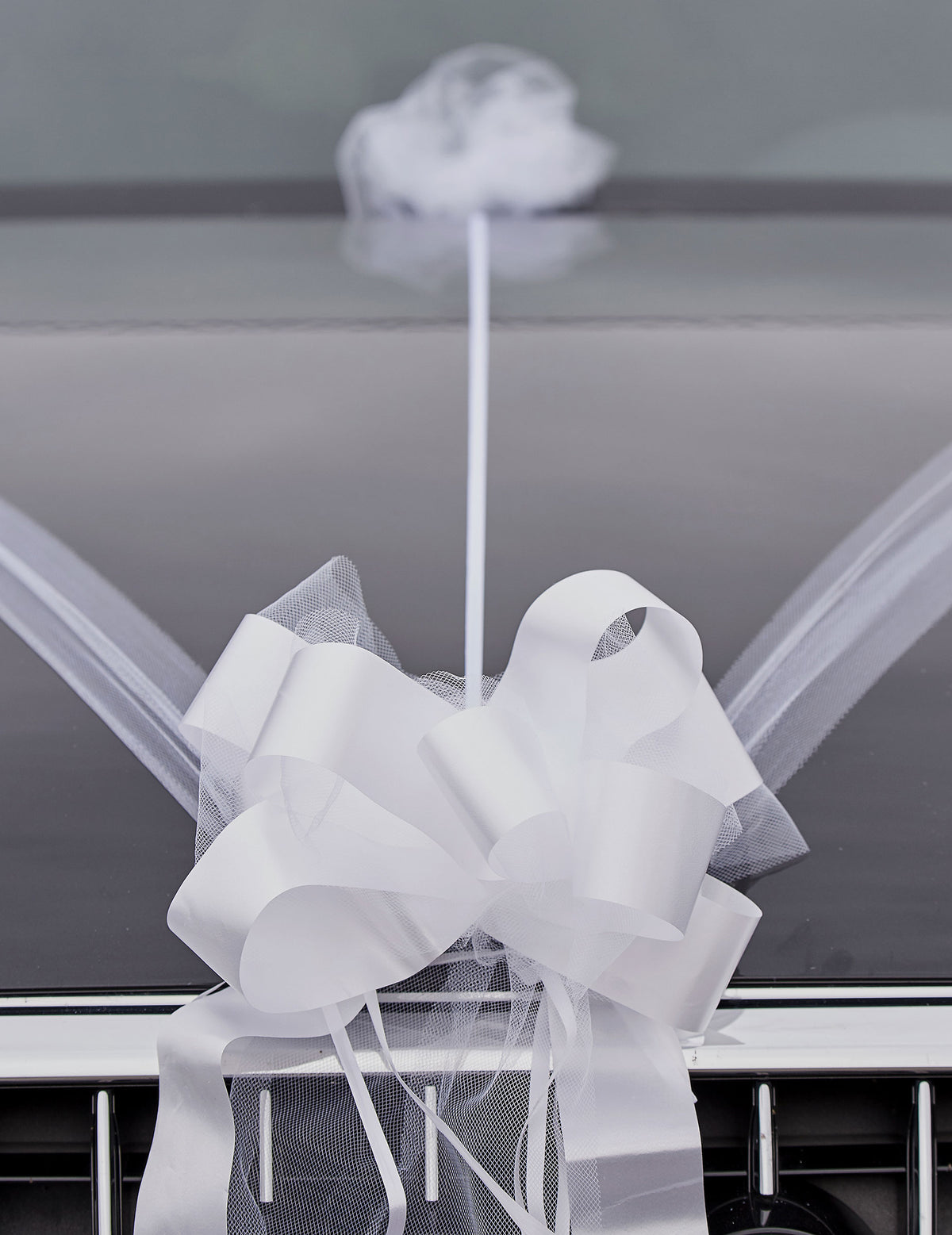 Gros plan sur le nœud en tulle et ruban du kit de décoration voiture mariage