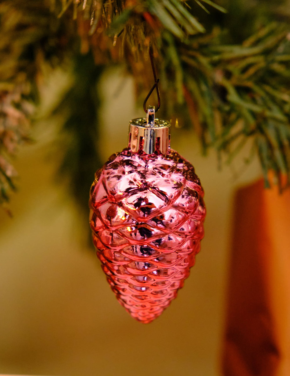Gros plan sur une pomme de pin brillante du kit de décorations de sapin rose gold
