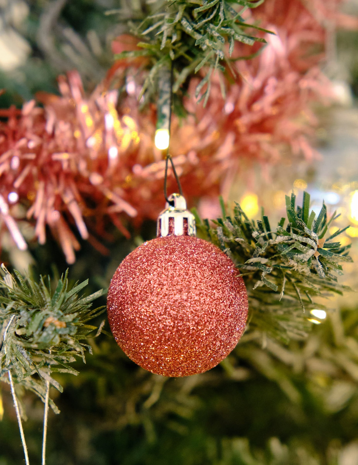 Gros plan sur une boule pailletée du kit de décorations de sapin rose gold