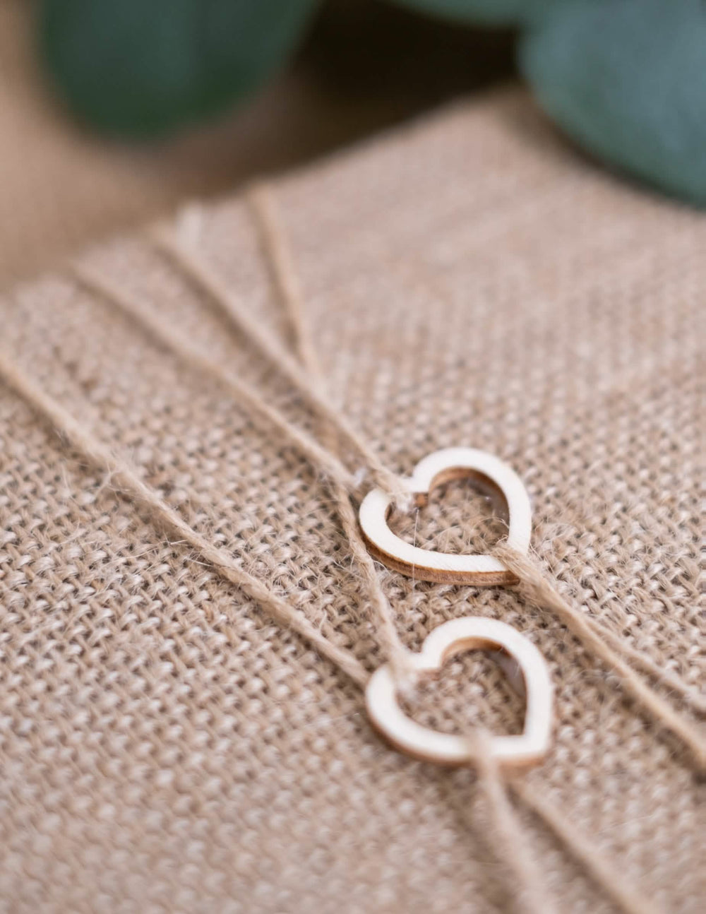 Detalhe dos pequenos corações em madeira e do fio do livro de honra de casamento nature