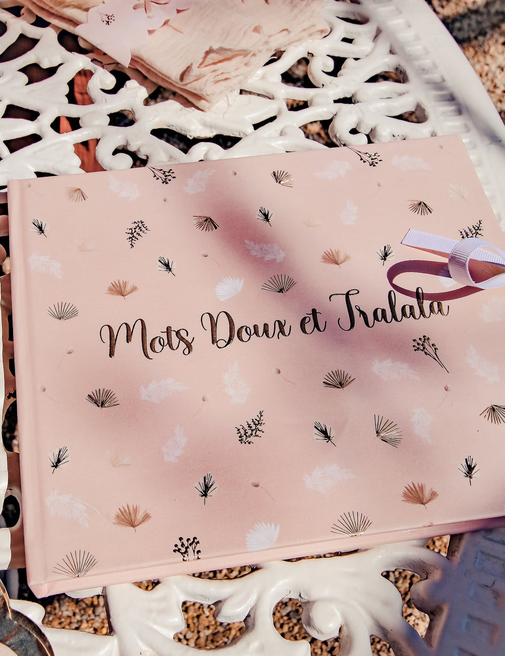 Gros plan sur le lettrage doré de la couverture du livre d'or boho