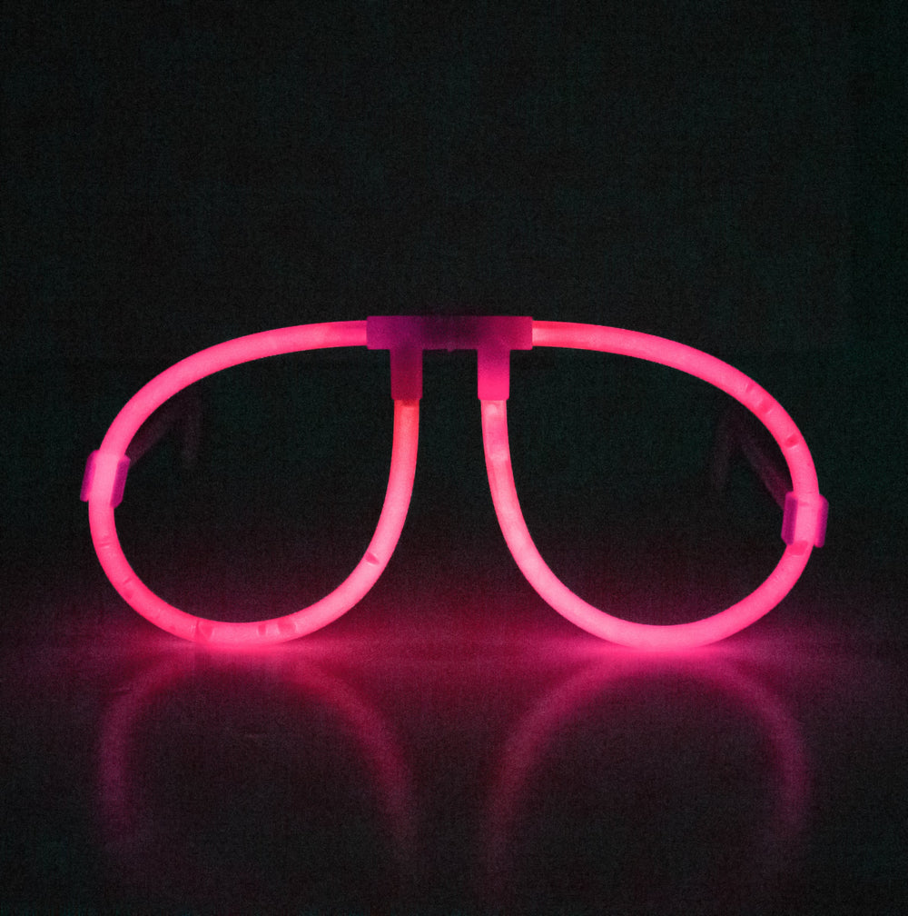 Vue de face illuminée rose des lunettes phosphorescentes fluo