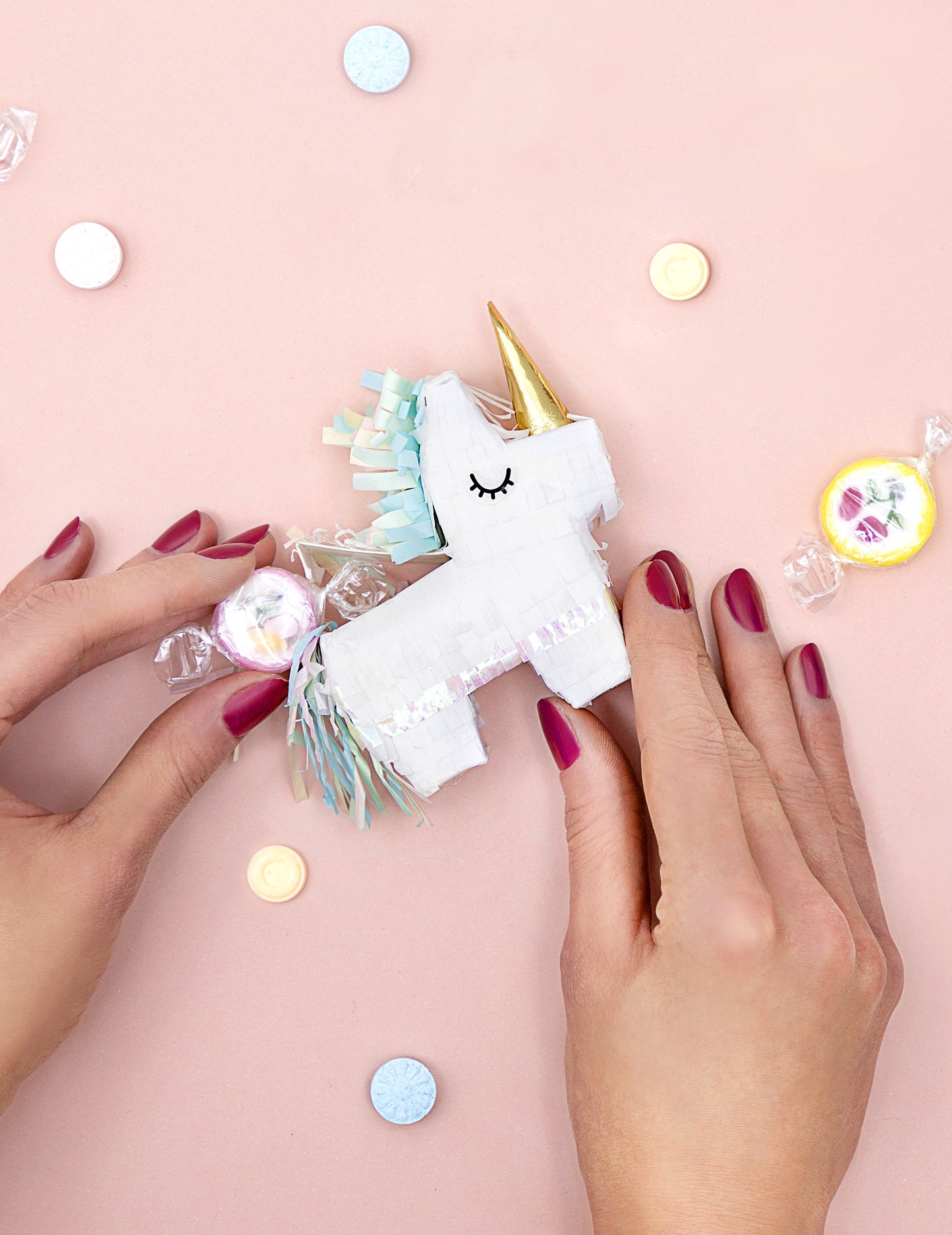 Détail du remplissage de bonbons de la mini piñata licorne blanche