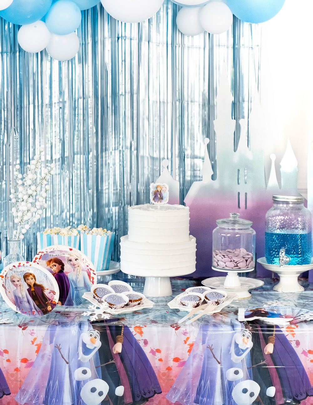 Mise en situation sur une table de fête de la nappe en plastique La Reine des Neiges 2