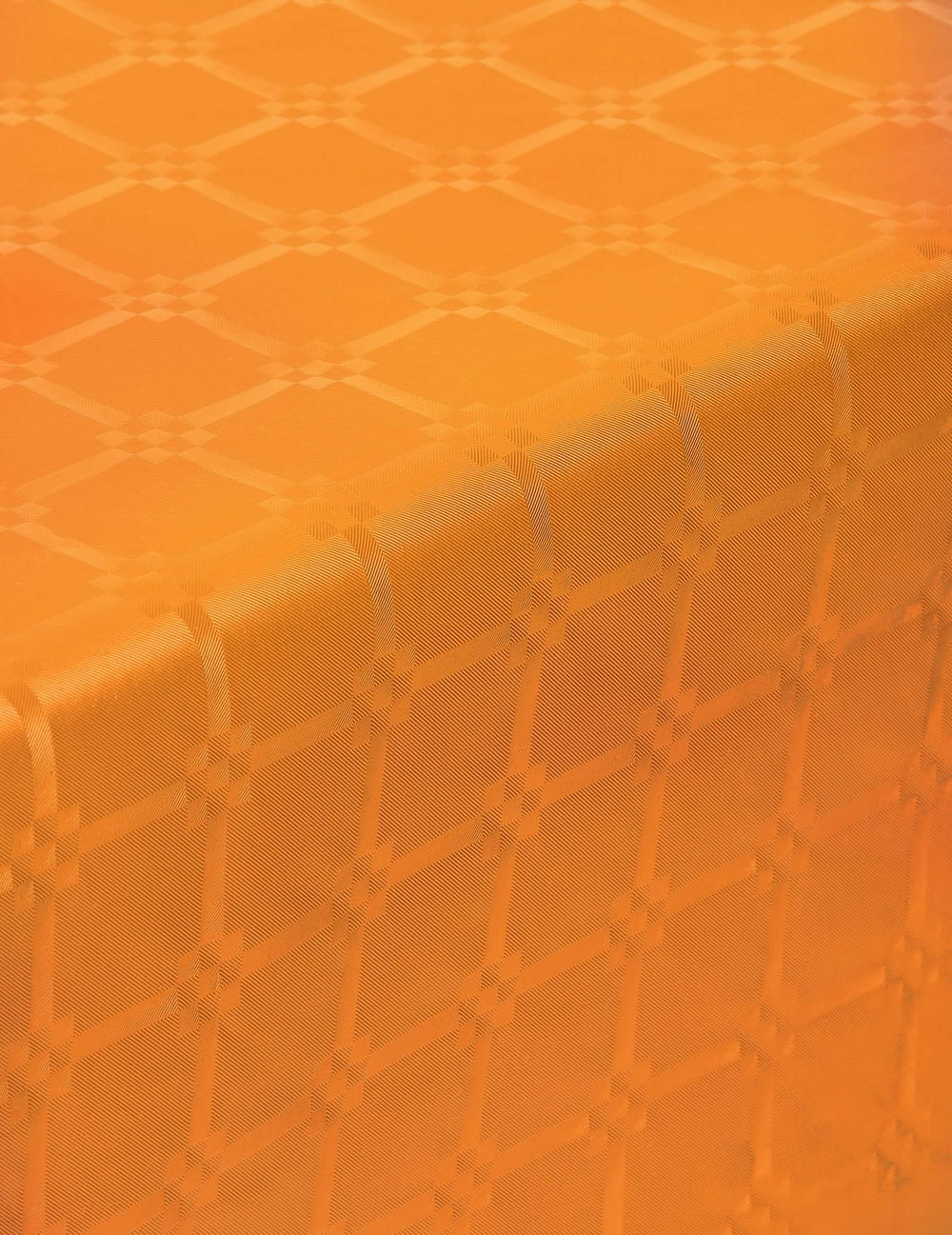 Grande plano dos padrões da toalha de mesa em rolo de papel damasco cor de laranja espesso