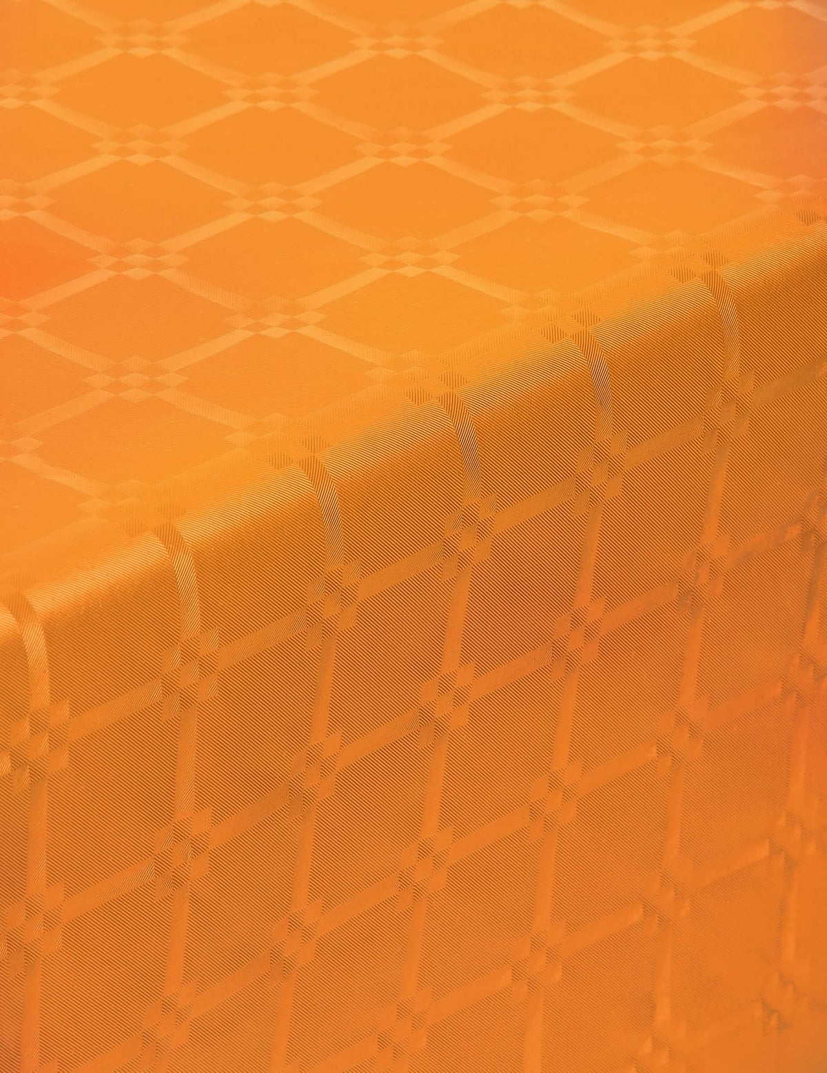 Grande plano dos padrões da toalha de mesa em rolo de papel damasco cor de laranja espesso