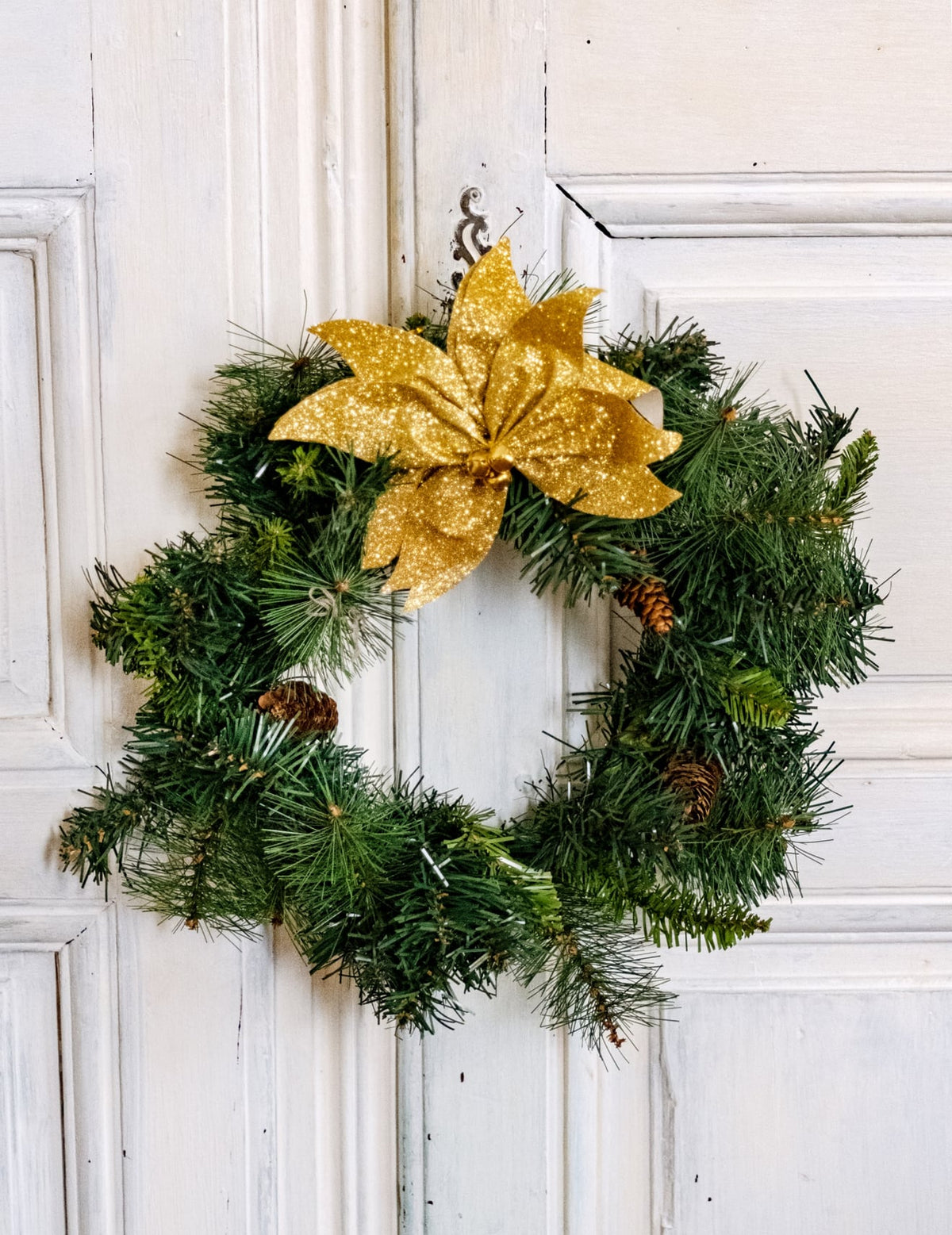 Mise en situation sur une couronne du nœud de poinsettia avec grelots pour table pailleté doré