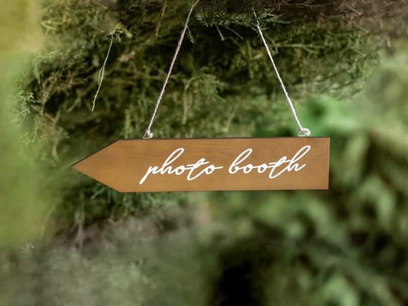 Suspensão em cenário da placa direcional de madeira photobooth