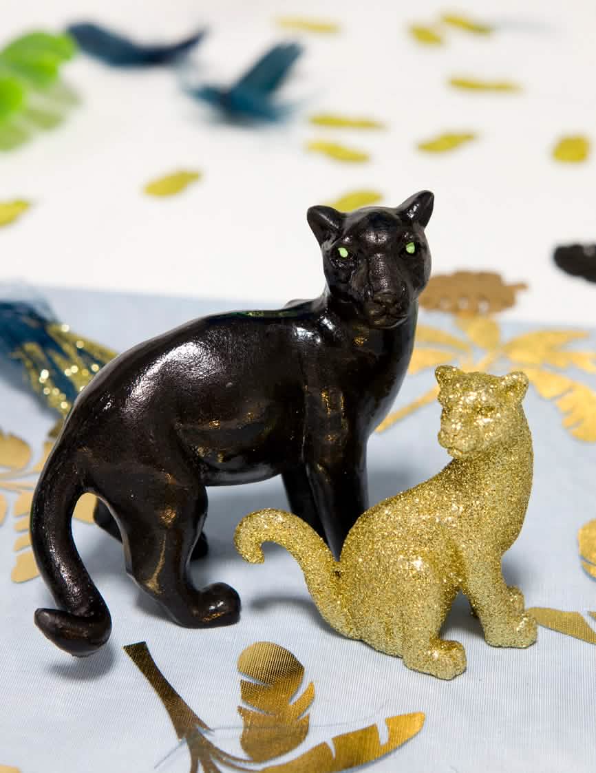 Cenário com uma figurinha dourada da pantera em resina tema selva