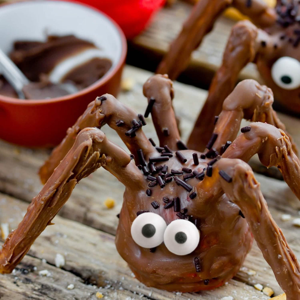 Cenário com aranhas de chocolate da decoração comestível pequenos olhos de açúcar