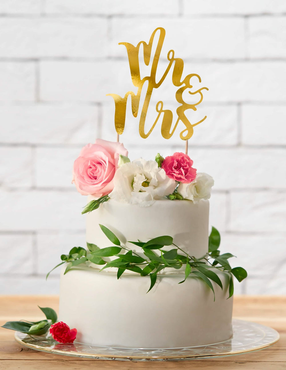 Colocação sobre um bolo do topo de bolo Mr e Mrs para casamento dourado em cartolina