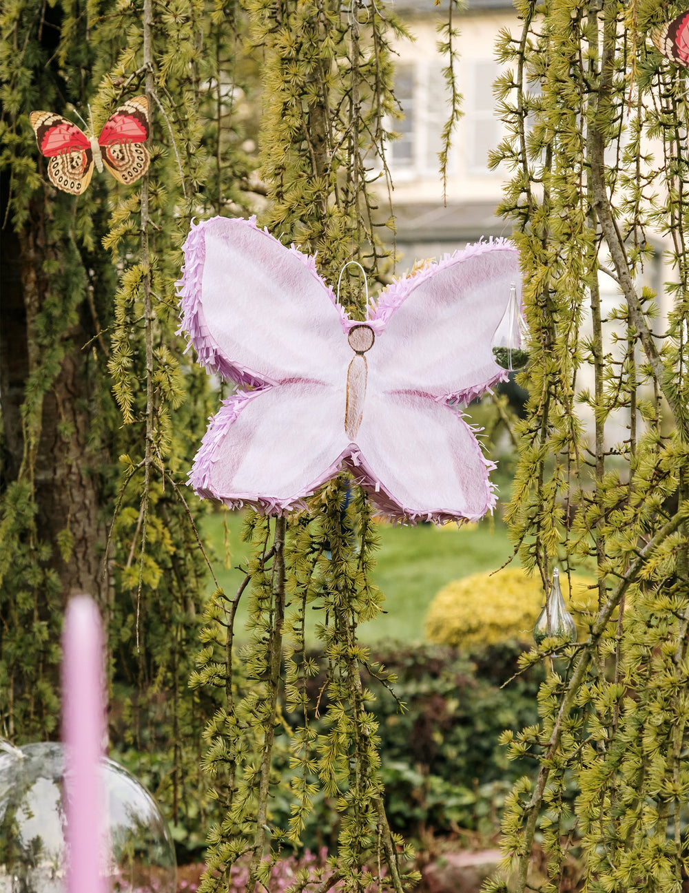 Mise en situation dans un jardin de la Piñata papillon pour anniversaire