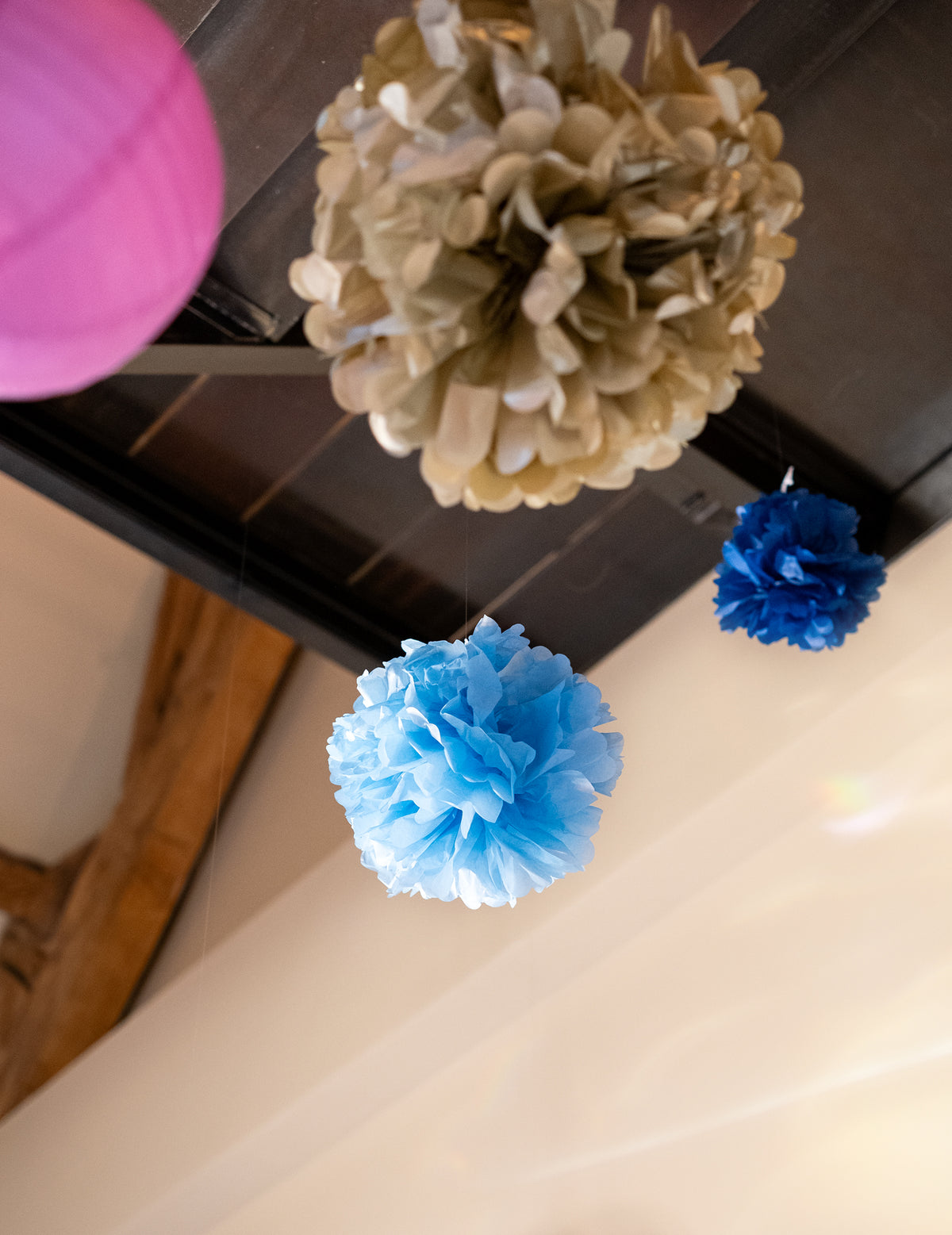 Vue de dessous du pompon à suspendre en papier de soie pour décoration bleu ciel