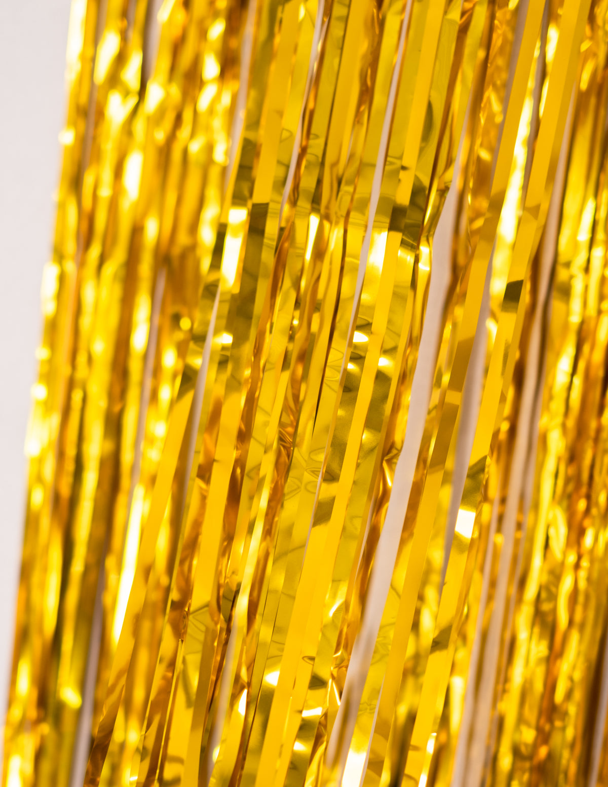 Détail de la brillance des bandes dorées du rideau scintillant pour décoration de fête