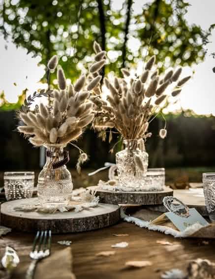 decoração de mesa com ramos de flores secas sobre um tronco de madeira natural para decoração