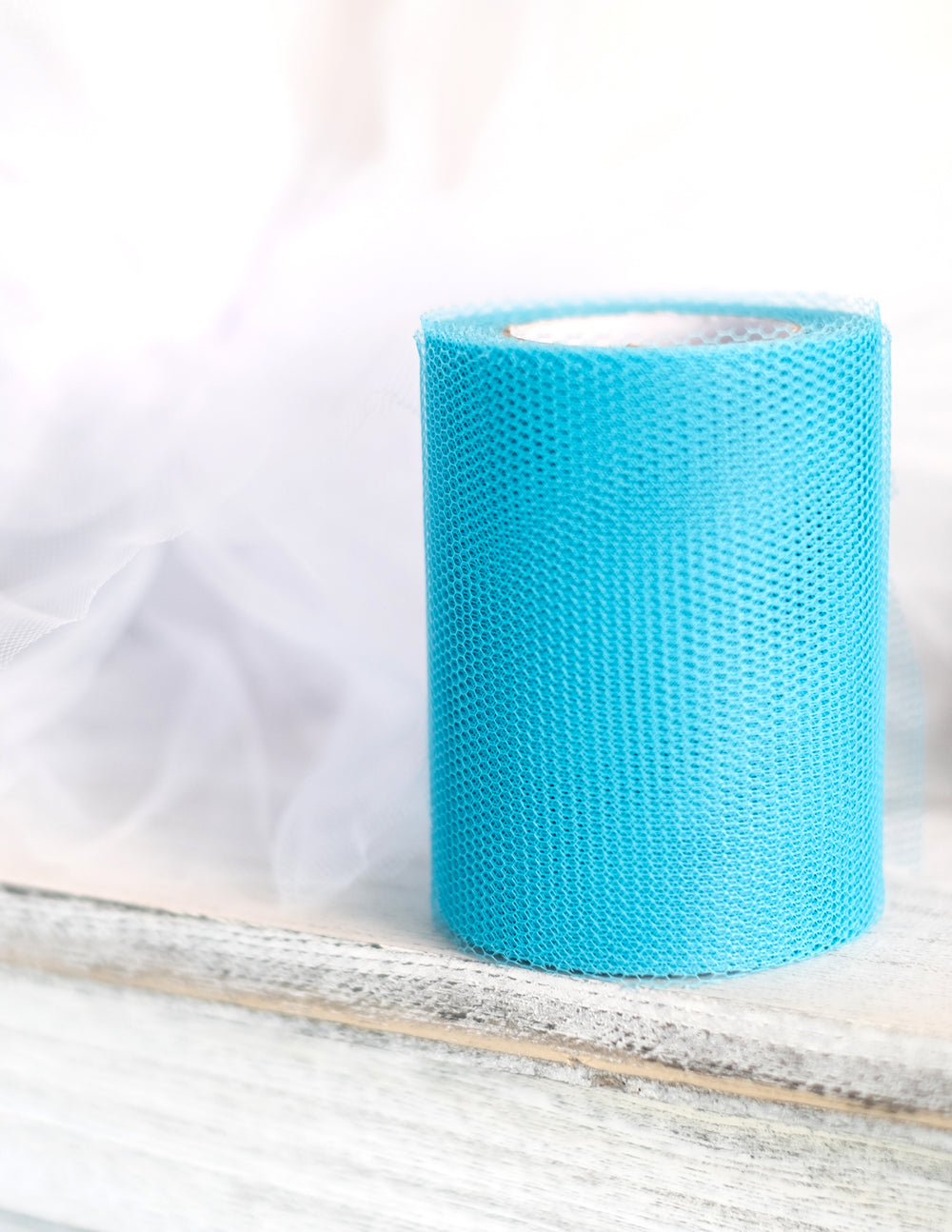 Gros plan du rouleau de tulle bleu turquoise 20 mètres et largeur 8 cm