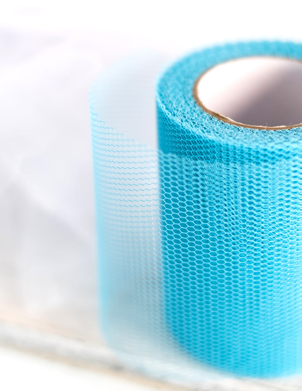 Zoom sur le maillage du rouleau de tulle bleu turquoise 20 mètres et largeur 8 cm