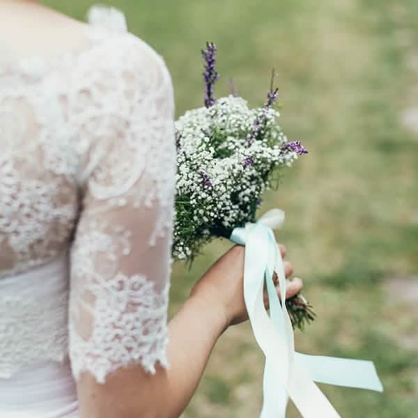 Detalhe da fita atada num ramo de flores da fita de cetim de casamento
