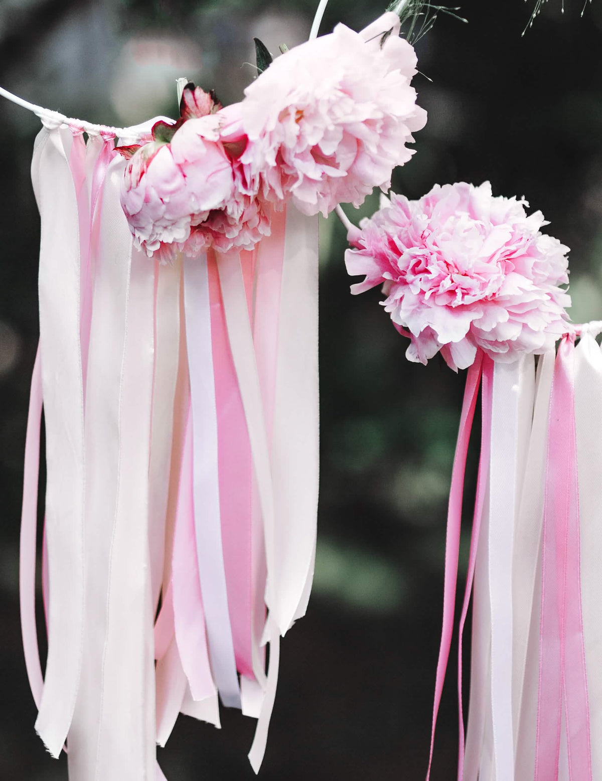 Grande plano sobre as flores decoradas com a fita de cetim cor de rosa