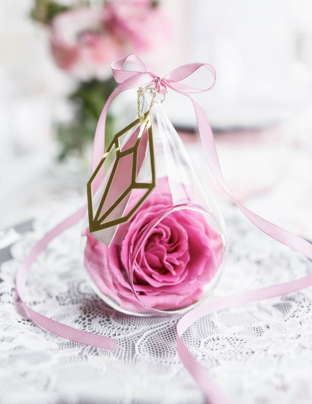 Laço decorativo numa bola de vidro com fita de cetim cor de rosa