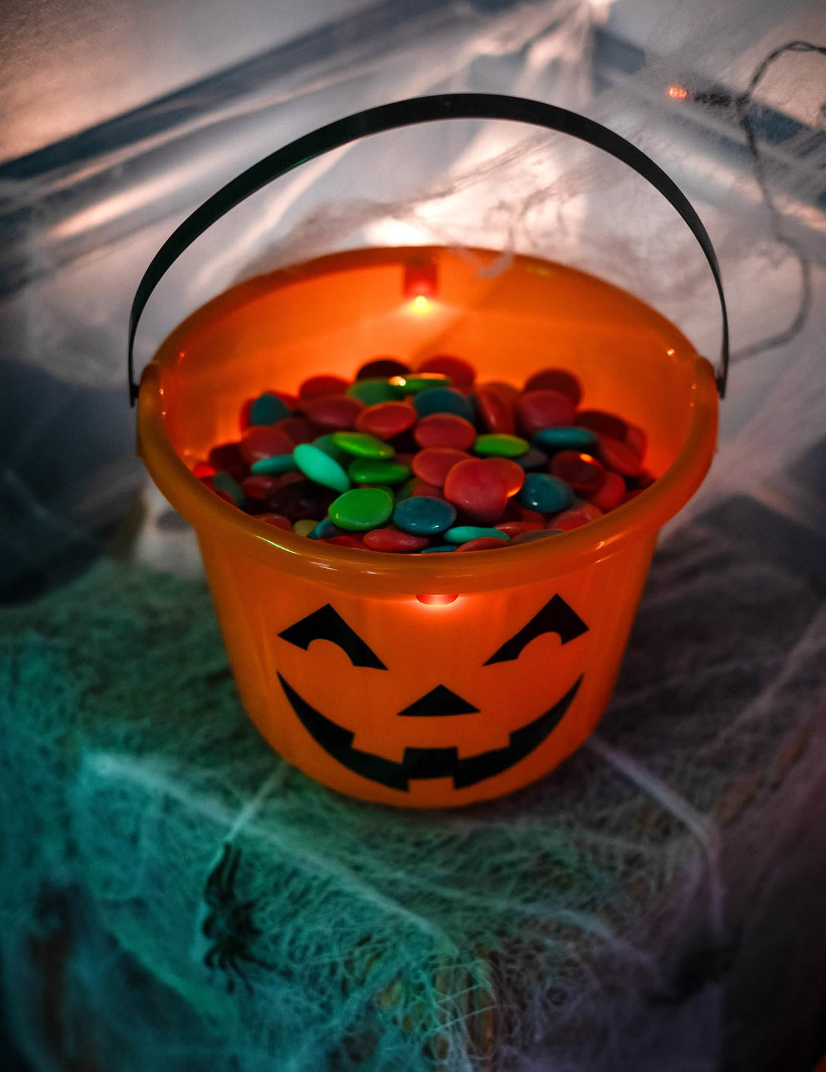 Grande plano dos rebuçados no interior do balde abóbora halloween