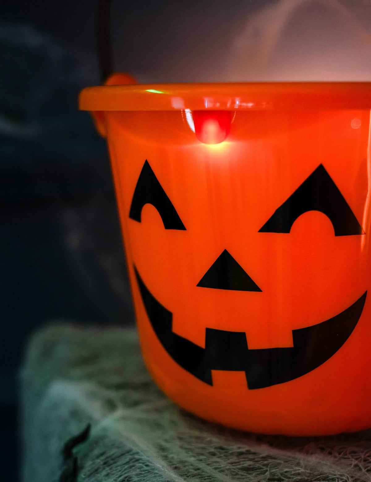Grande plano do rosto e da iluminação do balde abóbora para halloween