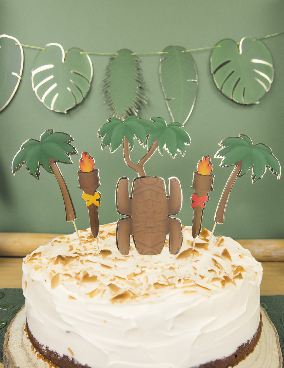 Gros plan sur les motifs tiki et palmiers des décorations pour gâteau aventurier