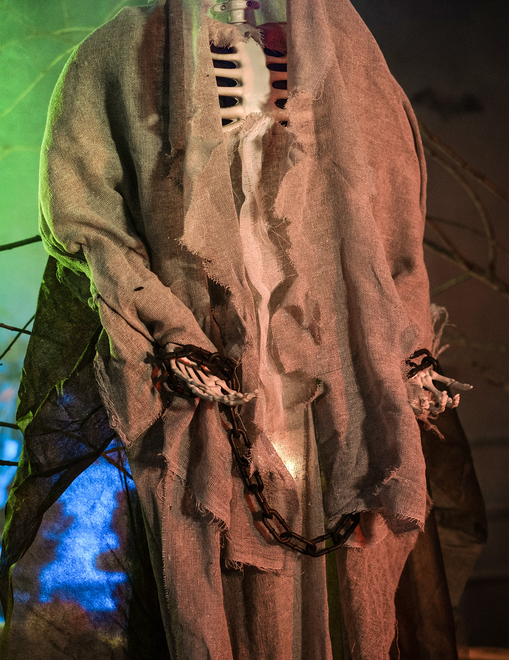 Gros plan sur les mains enchaînées du squelette lumineux à suspendre Halloween