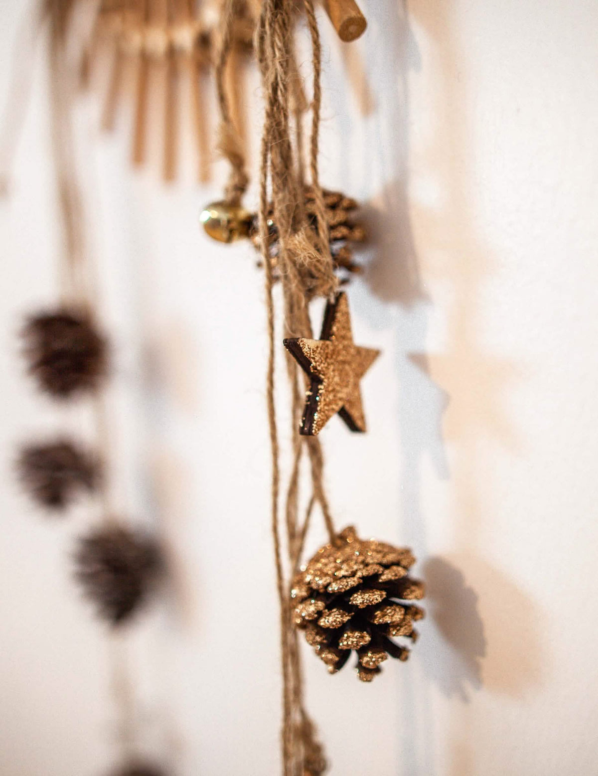Detalhe da estrela e dos brilhantes do pendente de pinhas e estrelas de madeira para decoração brilhantes cobre