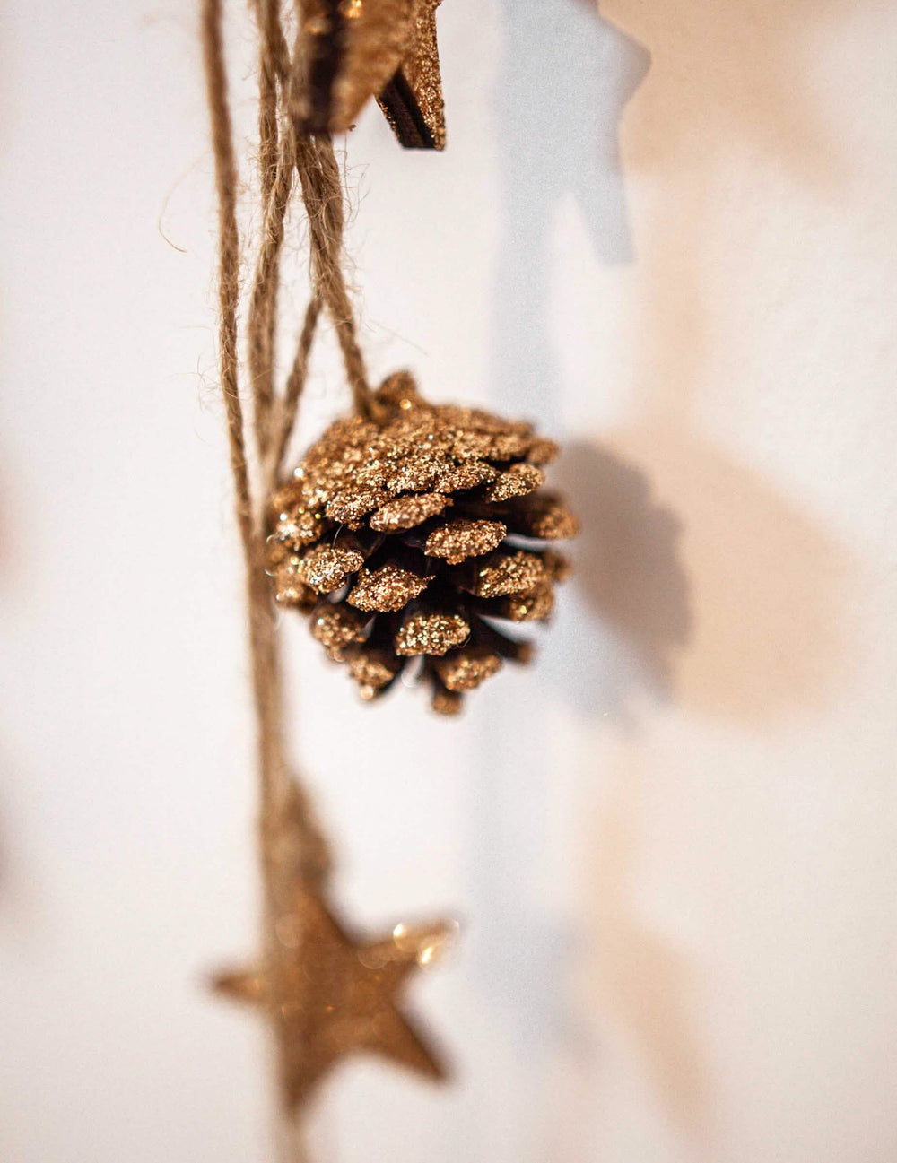 Grande plano do pinha com purpurina do pendente pinhas e estrelas de madeira para decoração com purpurina cobre
