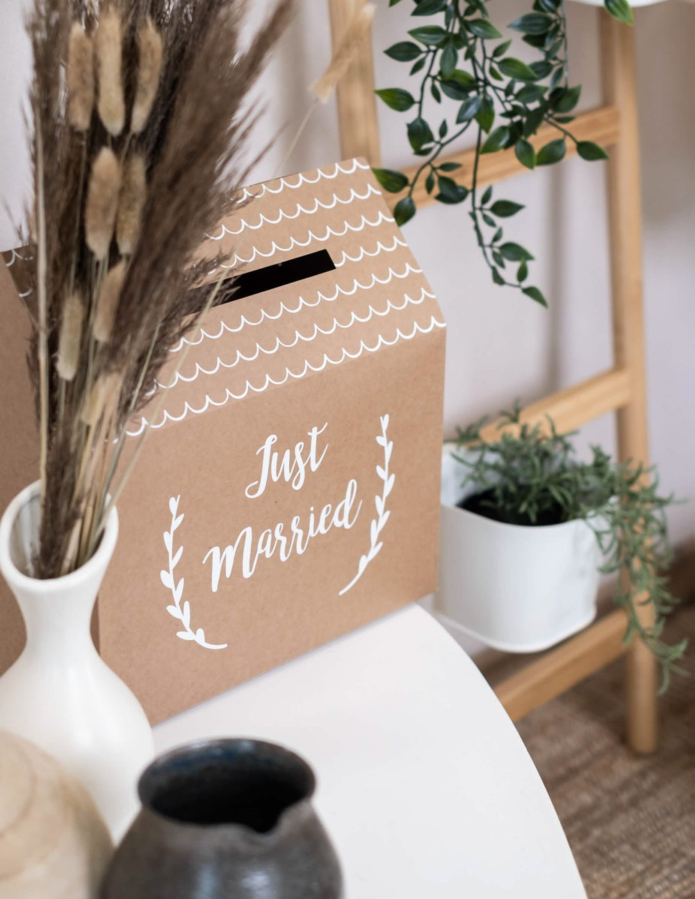 Vista de três quartos da urna em cartão kraft Just Married em forma de casa