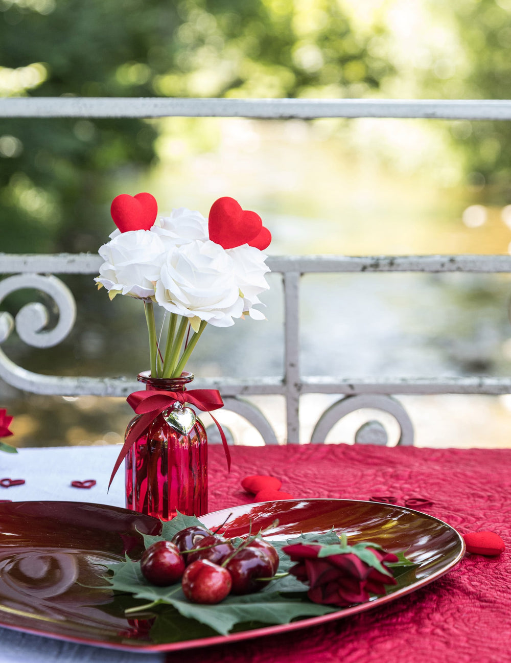 Mise en situation de table du vase en verre décoration ruban cœur rouge et argenté